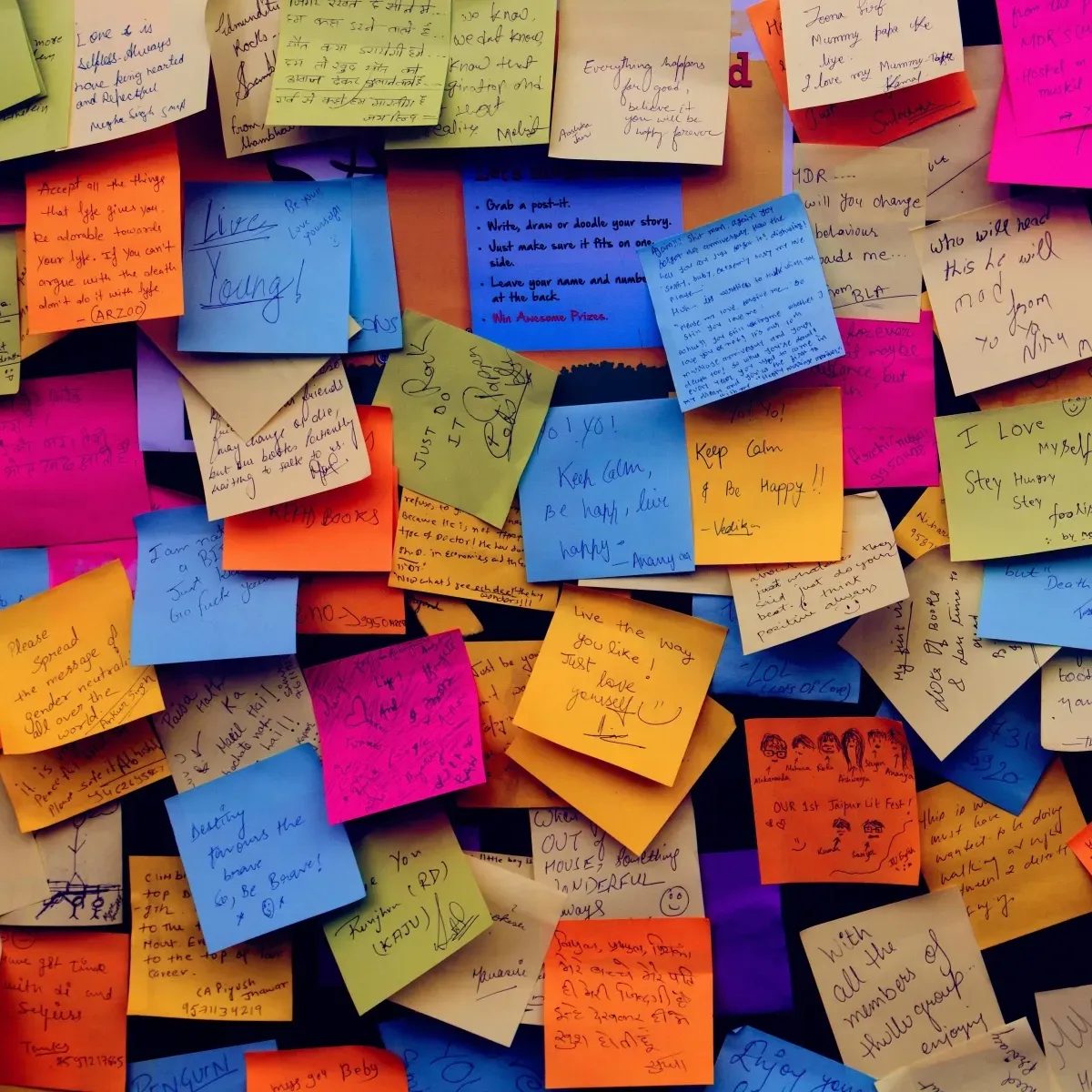 Post-it colorati con scritture diverse che rappresentano la varietà della personalità analizzata attraverso la grafologia
